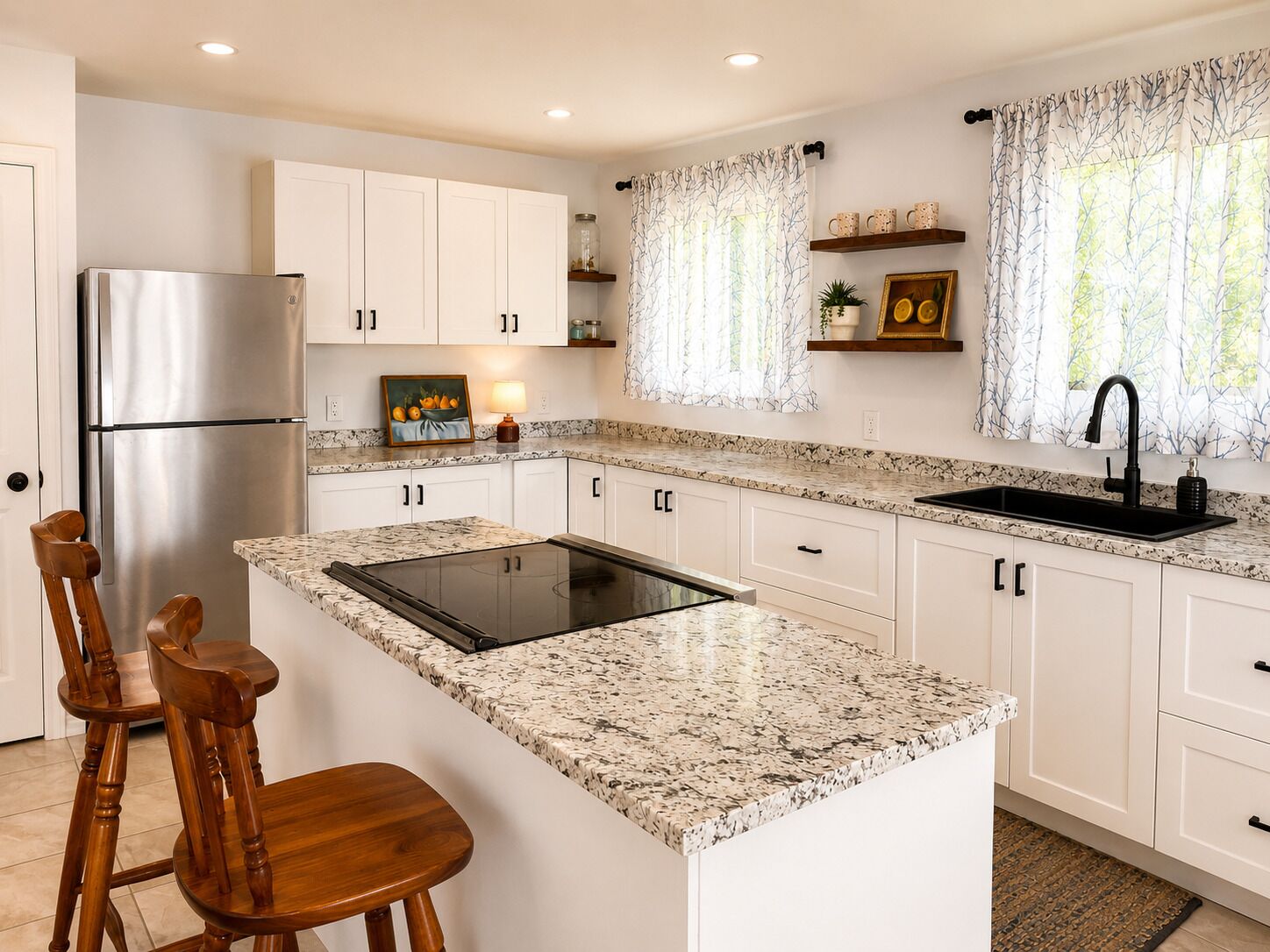 A kitchen with white cabinets, a stainless steel refrigerator, a black faucet, and a granite countertop.