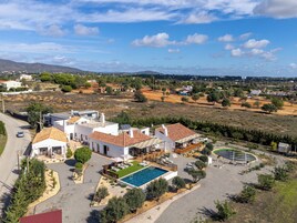 A residential area with a swimming pool, white houses, and a clear sky.