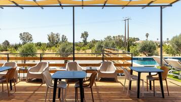 Relax in a shaded outdoor seating area with a pool view.