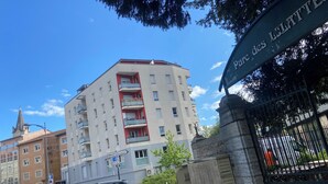 A multi-story building with balconies, a street sign, and a gate labeled "Parc des LITTES." - Apartment 85m2 short term rental 1 month 2 months 3 months max available (Bourgoin-Jallieu)