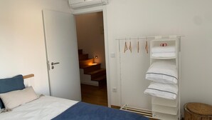 Une chambre à coucher comprenant un lit, une armoire et un appareil de climatisation.