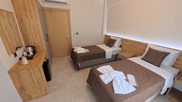Une chambre d’hôtel avec deux lits, une armoire en bois, un coin café et un appareil de climatisation.
