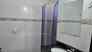 Un baño con inodoro, lavamanos y espejo.