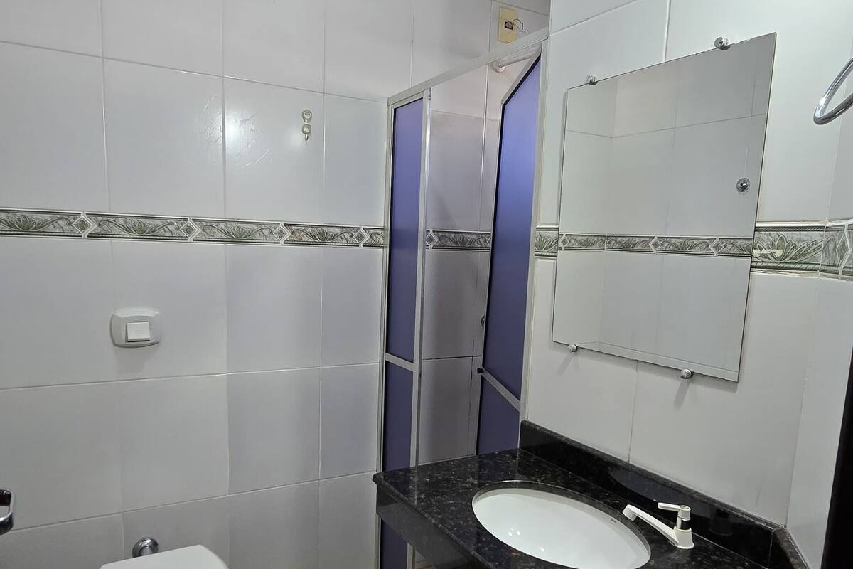 A bathroom with a toilet, sink, and mirror.
