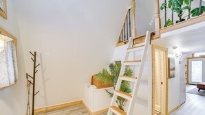 Eine Treppe mit einem hölzernen Geländer und einer weißen Wand mit einem kleinen, weißen Schrank.