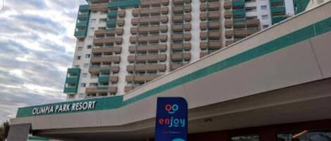A multi-story hotel with a sign reading "Olympia Park Resort" and a logo for "enjoy."