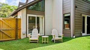 A house with a covered patio area, two Adirondack chairs, and a small table. - Renovated! Coastal 3 Bedroom in the Heart of MTP (Mount Pleasant)