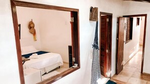 A hotel room with a bed, a mirror, and a hanging towel rack. - Vai Dá Certo Pousada  (Jijoca de Jericoacoara)