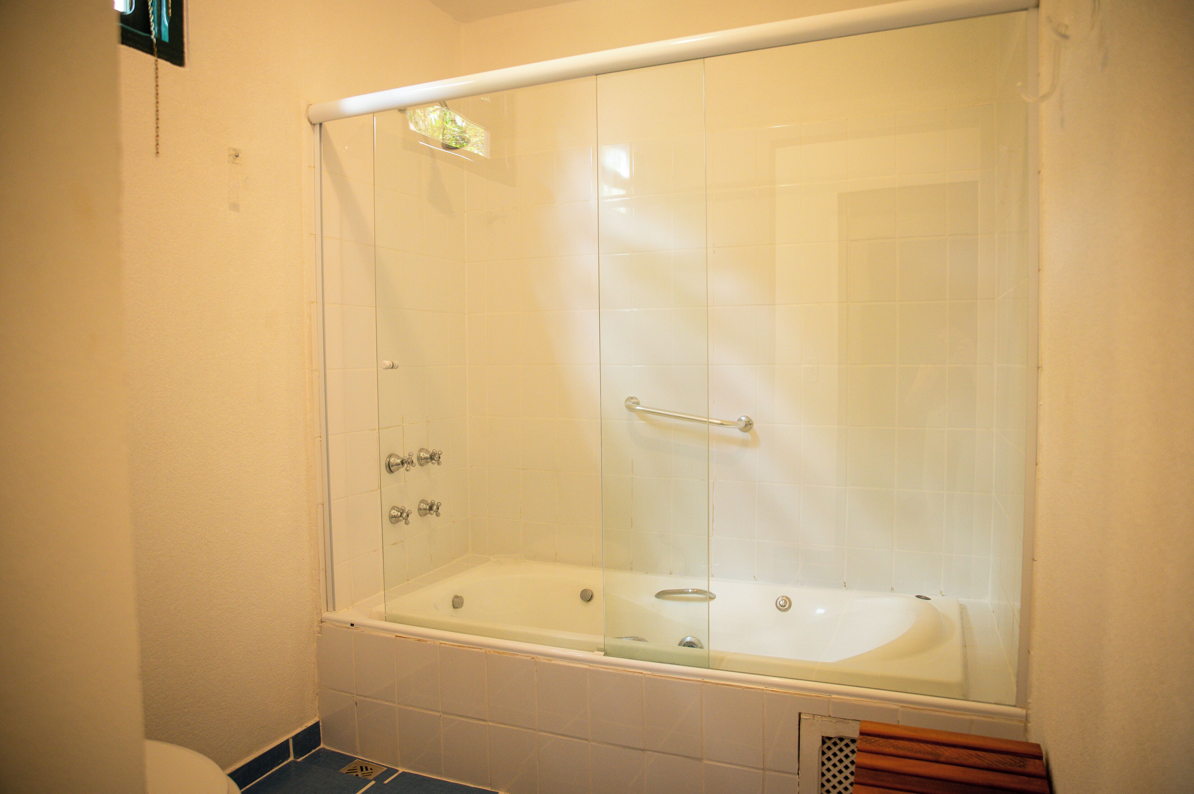 Une salle de bain avec une douche à parois de verre, une baignoire et des toilettes.