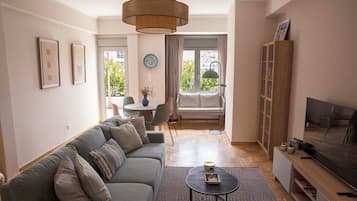 Apartamento conforto, 1 cama Queen e sofá-cama, cozinha, vista para a montanha | Área de estar | Smart TV 43 cm com canais digitais