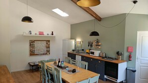 Una cucina compatta con piano di lavoro in legno, forno a microonde integrato e piano cottura a gas.