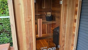 Una sauna con revestimiento de madera, puerta de vidrio y un cartel que dice 'alpine saunas'.