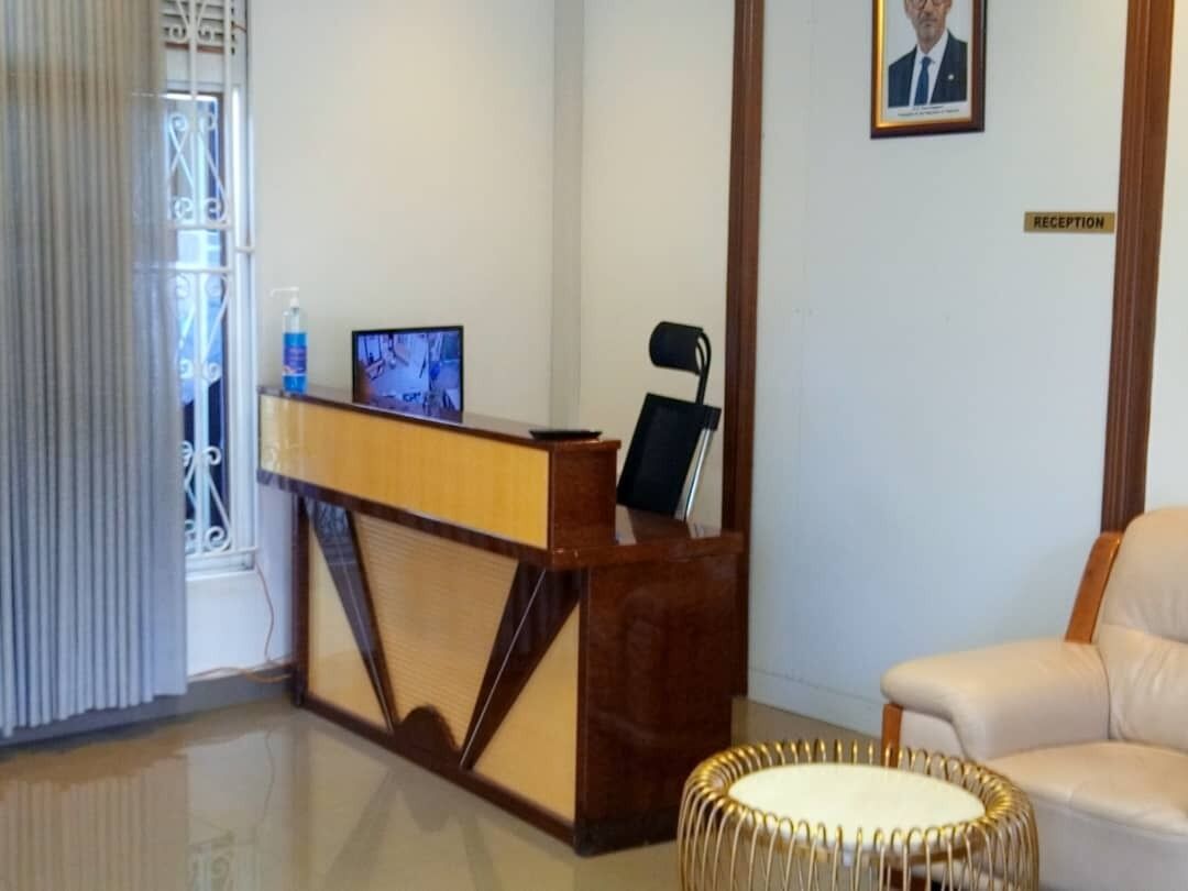 A reception area with a wooden desk, a television, a chair, and a framed picture on the wall.