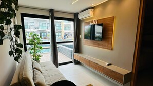 Un salon moderne avec un canapé, une table basse et un téléviseur fixé au mur.