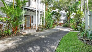 A two-story building with a covered porch and a pathway leading to the entrance.