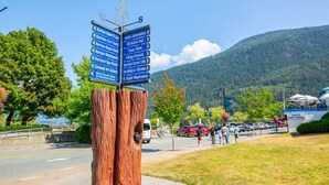 A directional signpost with multiple arrows pointing to various local attractions and amenities. - The Driftwalk | Walkable to Beach (Harrison Hot Springs)