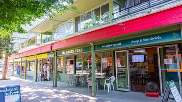 Vista de la calle de un restaurante llamado 'The Green Star', con mesas al aire libre y un cartel que anuncia 'Breakfast Special'.