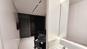 Une salle de bain moderne avec un grand miroir, un lavabo et une chaise.