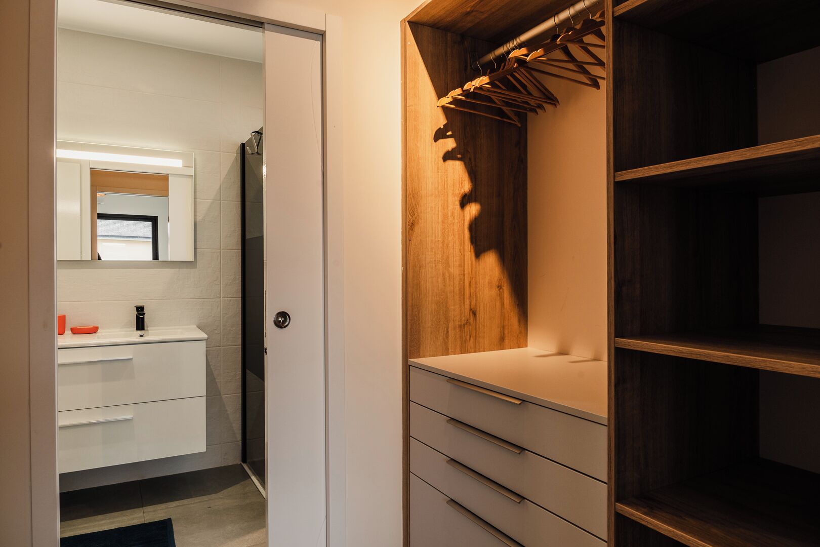 Une salle de bain moderne avec un meuble-lavabo blanc, un miroir et une douche.