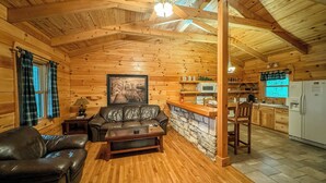 L’intérieur d’une cabane en rondins comprend un salon, une cuisine et un coin repas.