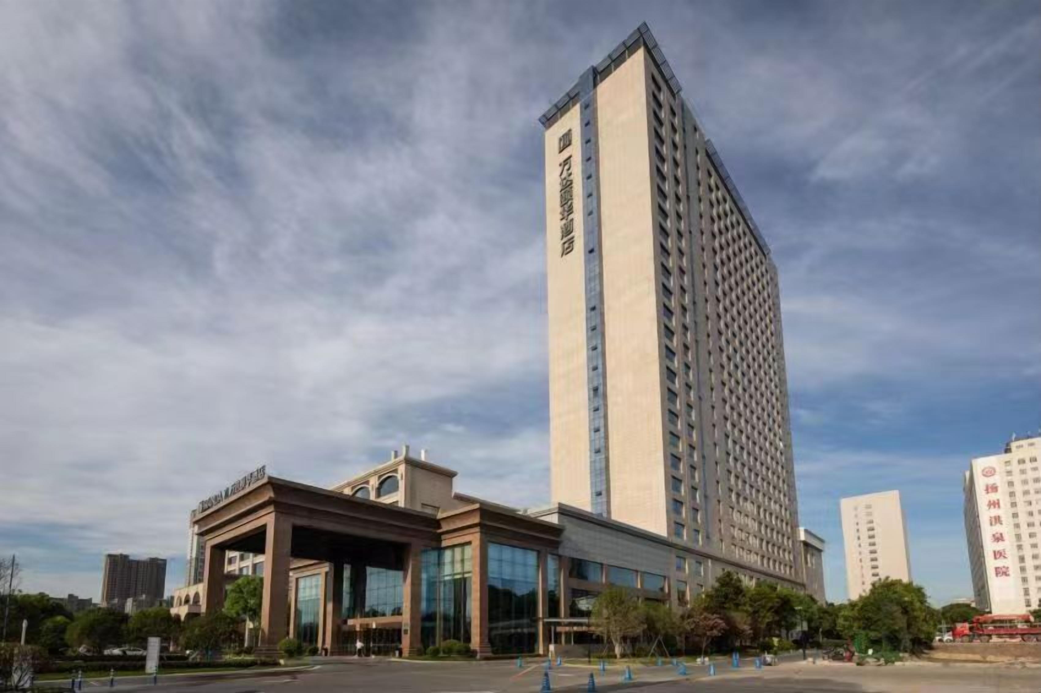 A tall hotel building with a modern design, featuring a prominent entrance with large glass doors and a flat roof.