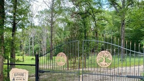 A gated entrance to Allen Acres Farm & Co. Resort with a signboard and decorative tree motifs on the gate.