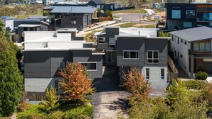 A modern residential complex with multiple two-story houses featuring flat roofs and large windows. - Stratton Summit 2, 5 bedroom townhouse in Jindabyne. (Jindabyne)