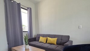 A living room with a sofa, a coffee table, and a dark armchair.