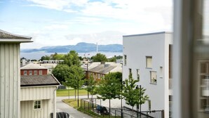 A residential area with modern buildings, a clear sky, and distant mountains.