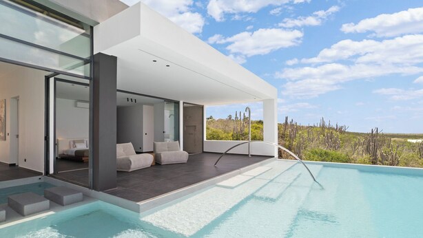 A modern outdoor pool area with a minimalist design, a clear view of the surrounding landscape, and a comfortable seating area. - Kas di Sol Infinito, NEW! Luxury Ocean View Villa w/ Huge Private Pool, 3 Bedrooms & Dive Facilities (Kralendijk)