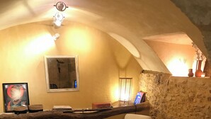 Een gezellige woonkamer met een open haard, comfortabele zitmogelijkheden en een rustieke stenen muur.