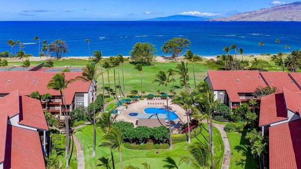 A resort with a central pool, surrounded by palm trees and a view of the ocean. -  2-bedroom apartment with WiFi, AC in Kihei (Kihei)