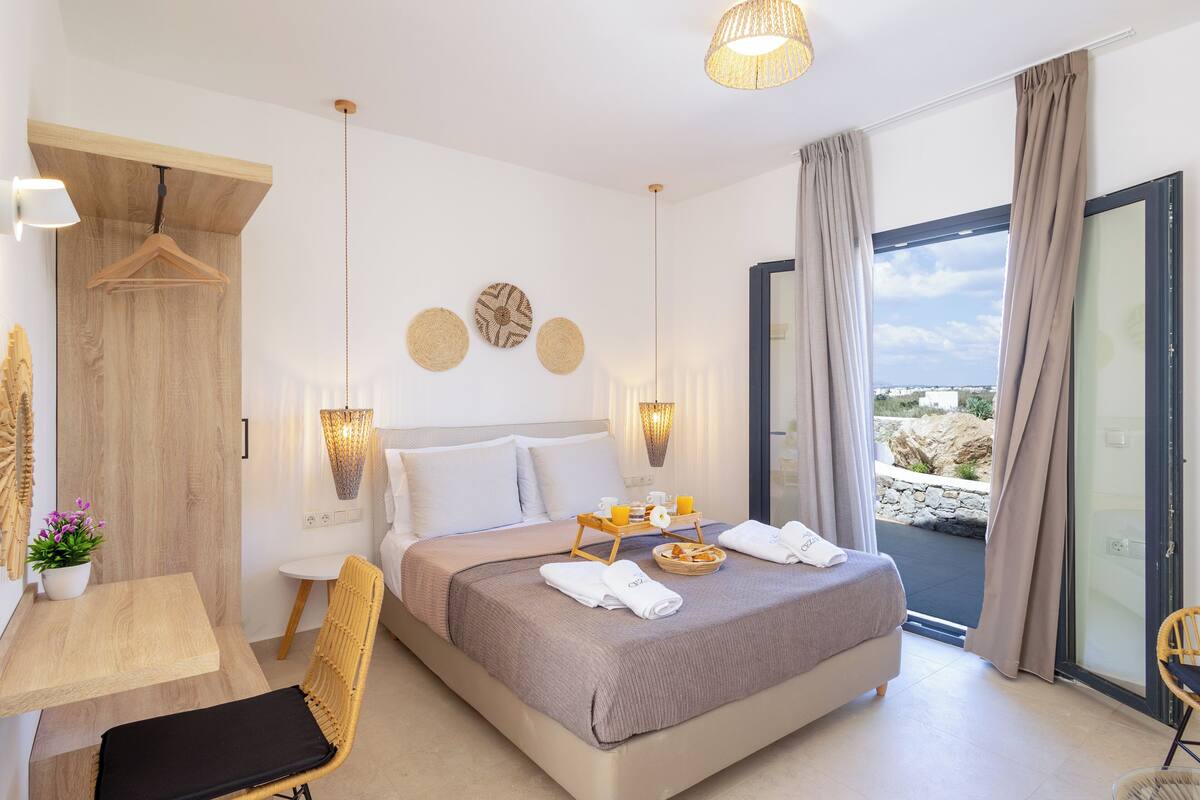 A modern bedroom with a bed, bedside tables, a desk, and a chair.
