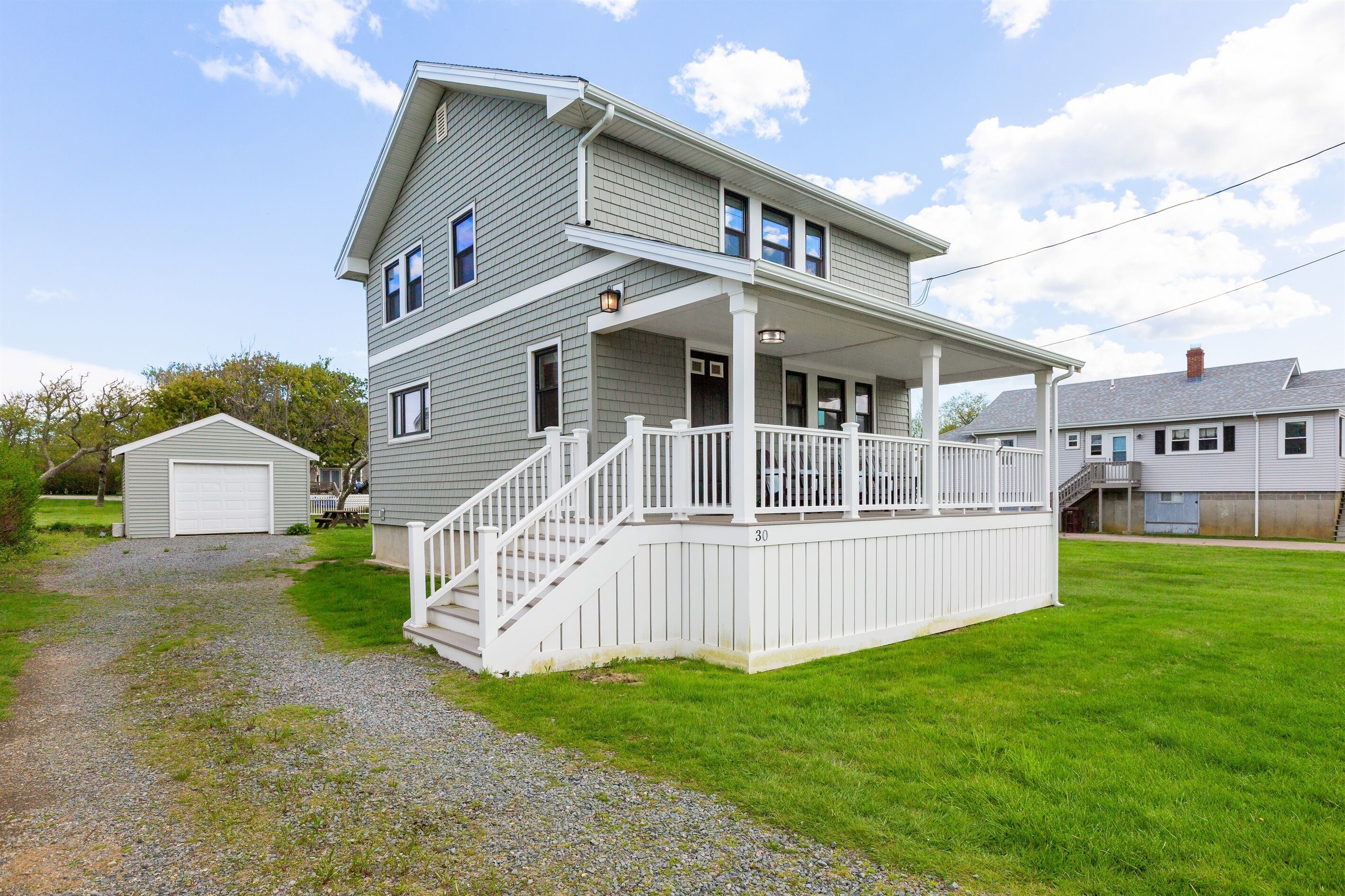 A two-story house with a covered porch and a small attached garage.