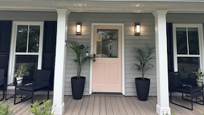 A house with a porch, two potted plants, and a door with a number plate. - NEW 30+ day Modern Coastal 4bdrm 2 Masters (Mount Pleasant)