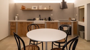 Une cuisine compacte avec une table de salle à manger ronde, des placards en bois et un four encastré.
