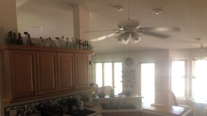 A kitchen with wooden cabinets, a dishwasher, and a ceiling fan.