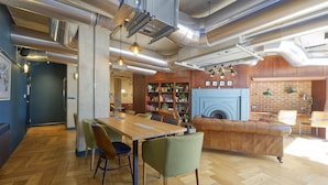 A modern interior with a wooden dining table, chairs, a leather sofa, and a fireplace. - Modern-style Student Studio in London (London)