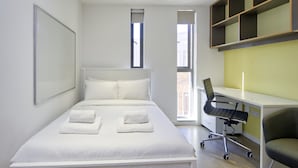 Une chambre à coucher moderne avec un grand lit, un bureau et une chaise.