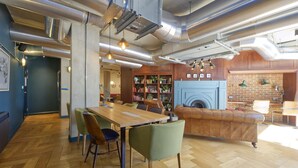 Un intérieur moderne avec une table à manger en bois, des chaises, un canapé en cuir et une cheminée.