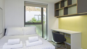 Ein modernes Hotelzimmer mit einem großen Bett, einem Schreibtisch und einem Stuhl.