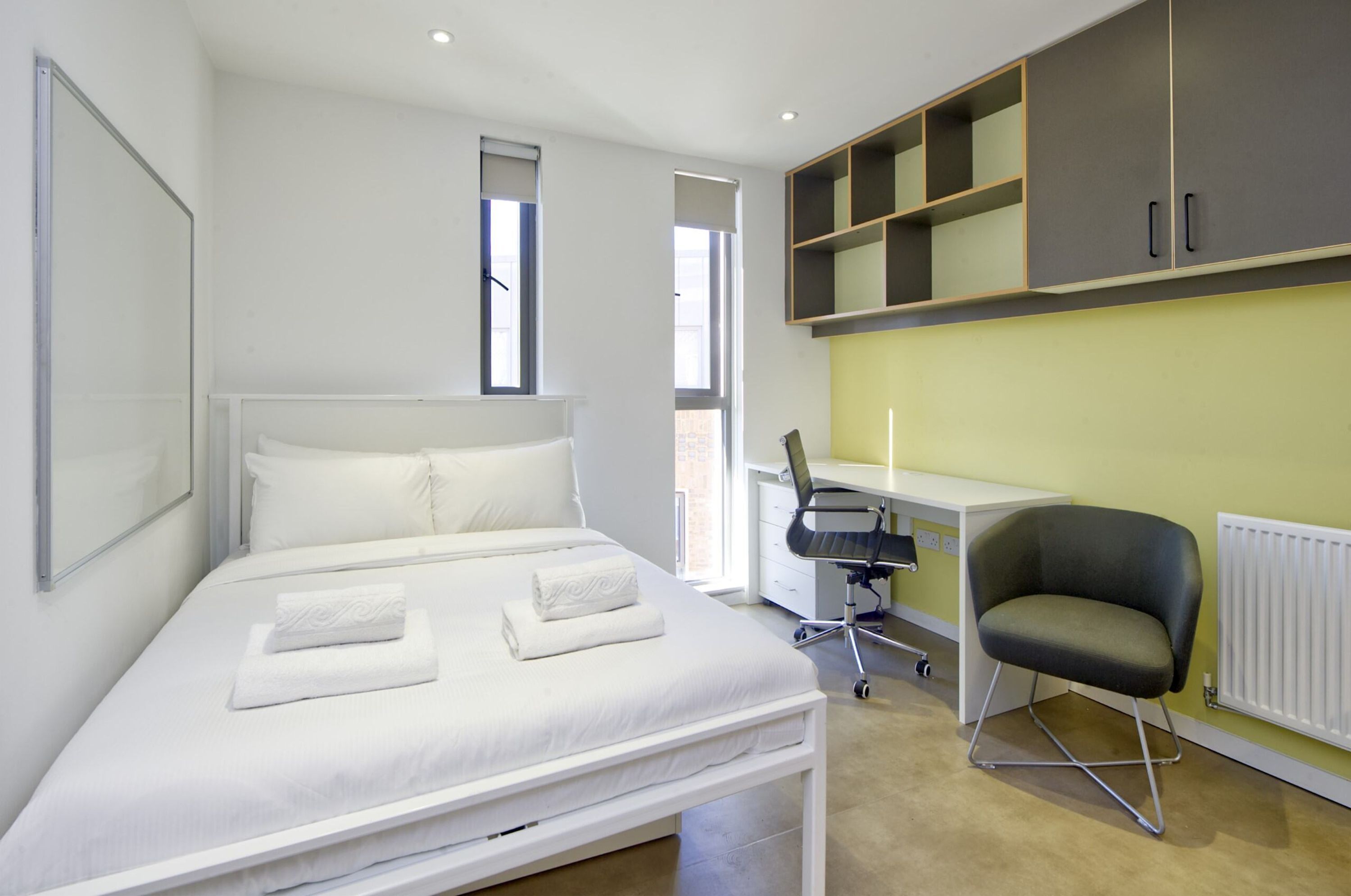 A modern bedroom with a bed, a desk, and a chair.