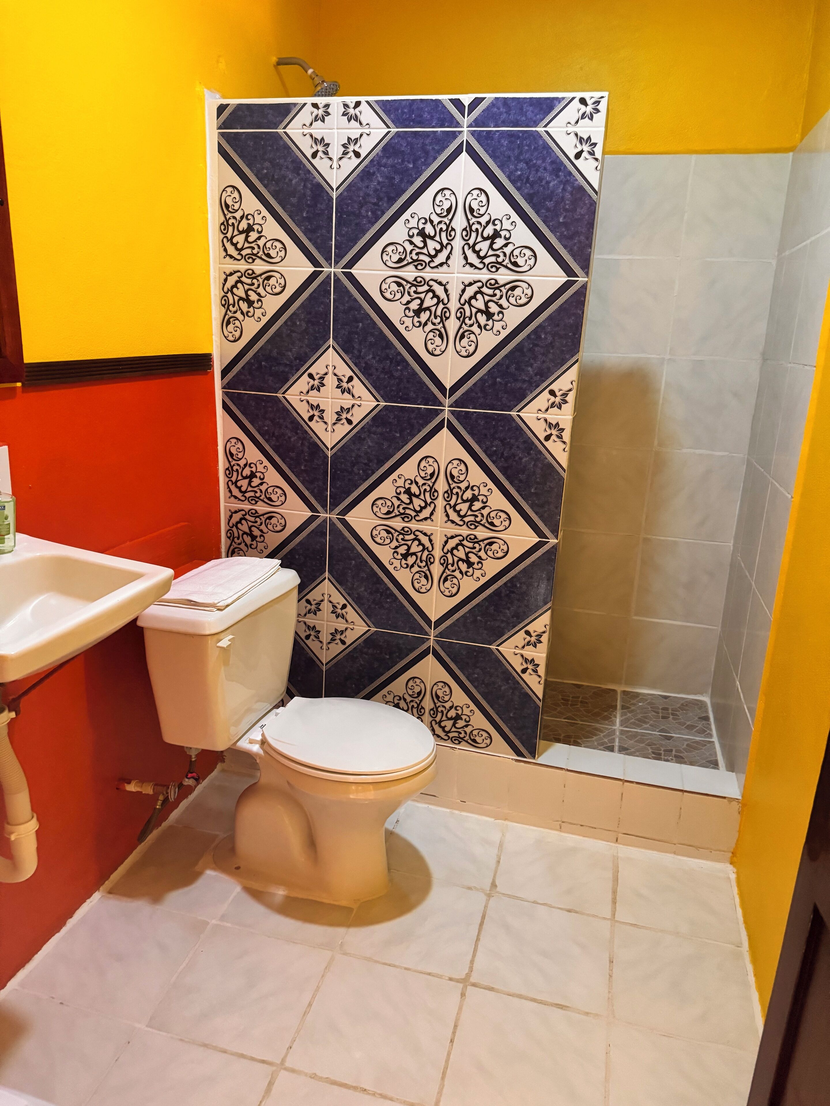 Un baño con inodoro, lavabo y zona de ducha.