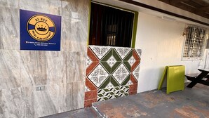 A hotel sign, a barred window, and a patterned wall. - EL REY MOTEL & RESTAURANT (Belmopan)
