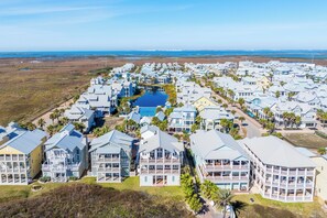 A coastal residential area with multiple two-story houses featuring balconies and a central swimming pool. - Sea of Dreams 174 SE (Port Aransas)