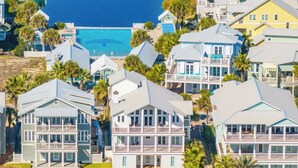 Un quartier résidentiel situé sur la côte, avec des immeubles à plusieurs étages dotés de balcons et de grandes fenêtres, offrant une vue sur la plage.