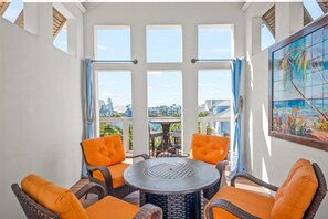 A sunlit patio with wicker furniture and a view of the cityscape. - Sea of Dreams 174 SE (Port Aransas)