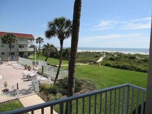 A hotel with a pool area, palm trees, and a view of the beach. - Oceanfront End-Unit | Pool View, Washer/Dryer (St. Augustine Beach)