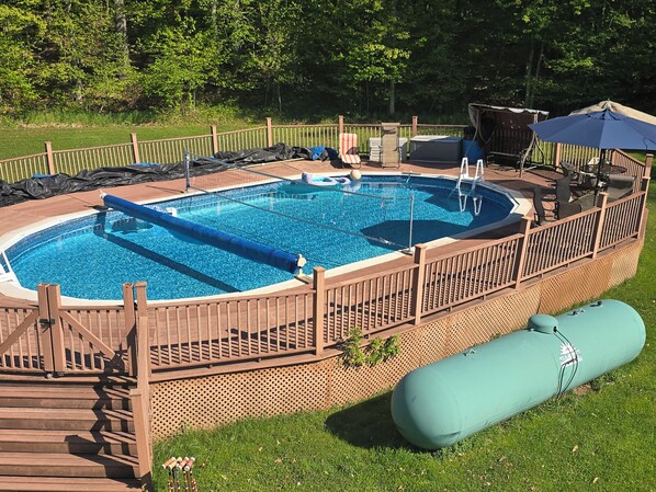 En swimmingpool med ett trädäck, ett avskärmat sittområde och en livräddarstation.