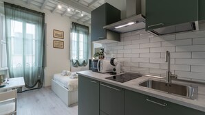 Una cocina moderna con armarios grises, un lavamanos de acero inoxidable y un horno empotrado.